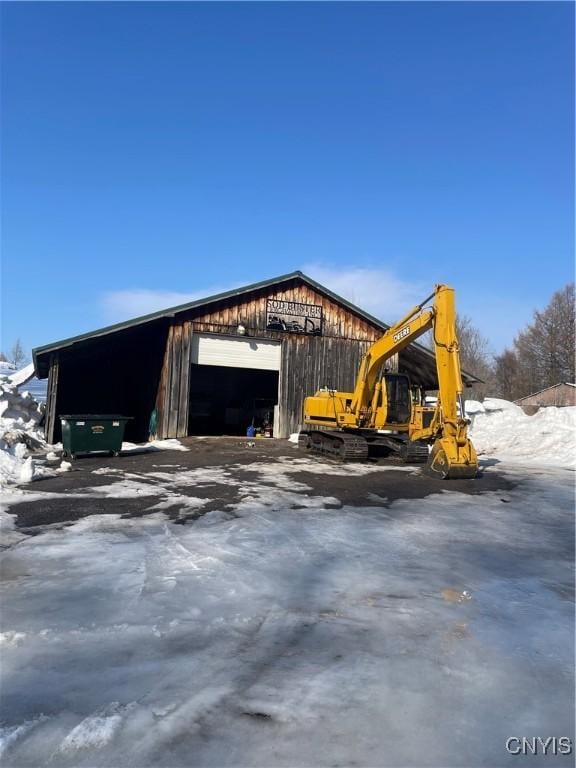 snow covered garage featuring a garage