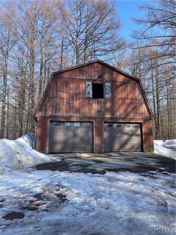 snow covered garage featuring a detached garage