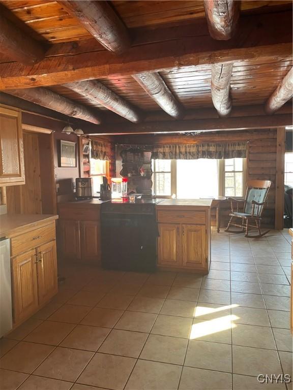 kitchen featuring beamed ceiling, light tile patterned floors, wood ceiling, and rustic walls