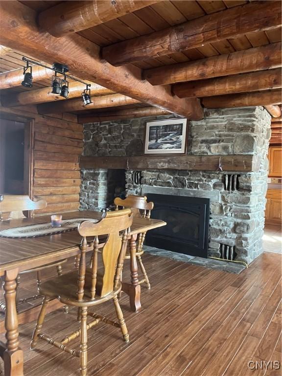 dining area with wood finished floors, wooden ceiling, and a fireplace