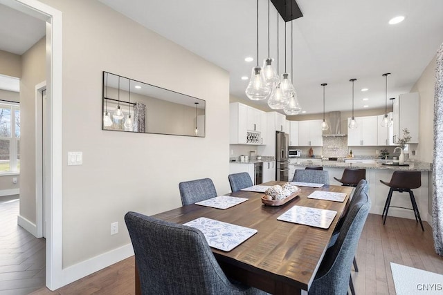 dining area featuring recessed lighting, baseboards, and wood finished floors