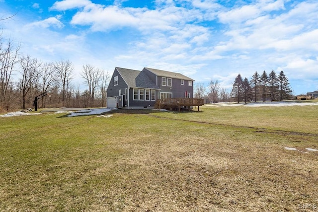 exterior space featuring a garage, a lawn, and a wooden deck