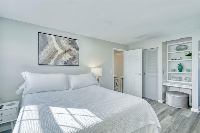 bedroom with baseboards, a closet, and light wood finished floors