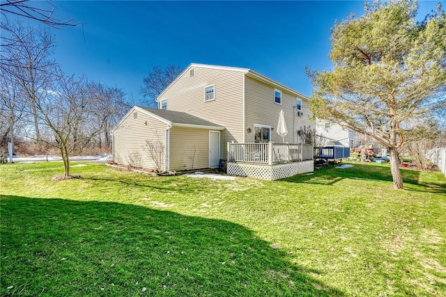 rear view of house featuring a wooden deck and a yard