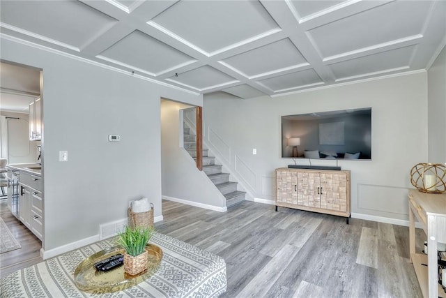 living room with stairway, coffered ceiling, baseboards, and wood finished floors