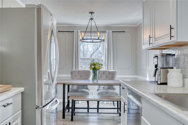 dining area with a notable chandelier, light wood finished floors, and ornamental molding