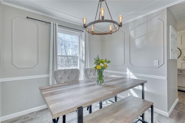 dining room featuring crown molding, a notable chandelier, and wood finished floors