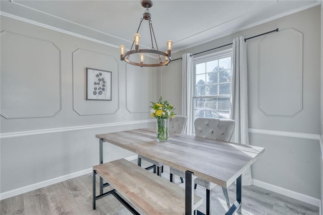 dining space featuring a notable chandelier, baseboards, light wood-style floors, and ornamental molding