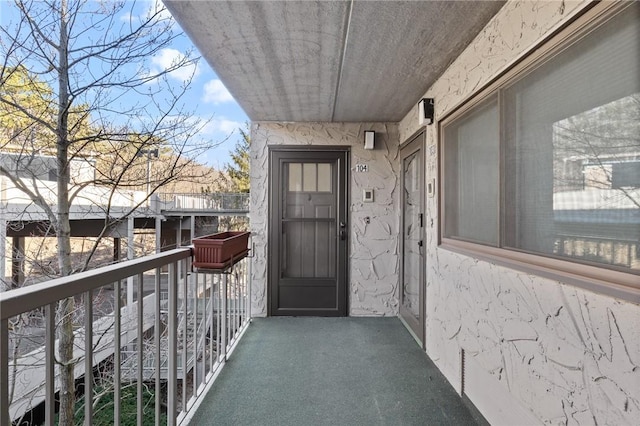 doorway to property featuring stucco siding and a balcony