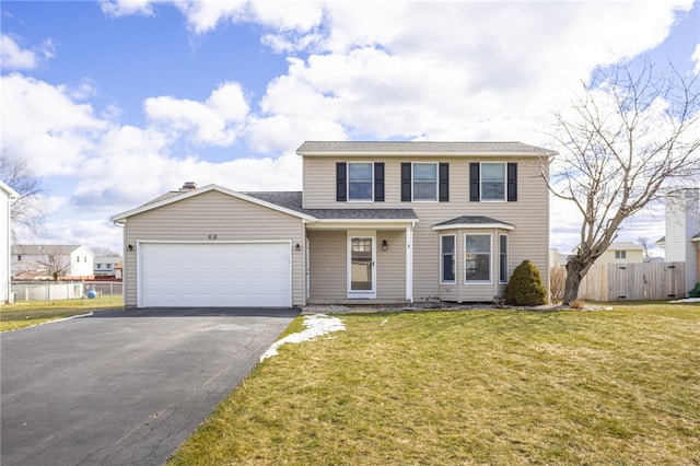 traditional-style home with a front yard, an attached garage, fence, and driveway