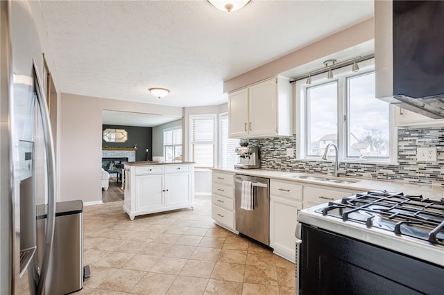 kitchen with a sink, decorative backsplash, white cabinetry, and stainless steel appliances