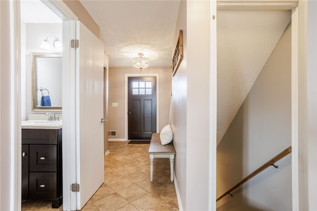 foyer entrance with visible vents, baseboards, and light tile patterned flooring