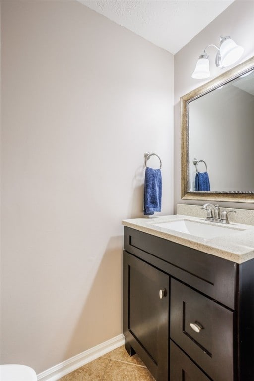 bathroom featuring vanity, baseboards, and tile patterned flooring