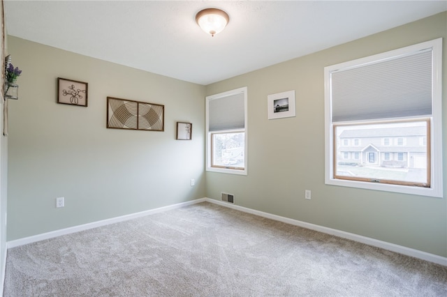 unfurnished room with visible vents, carpet floors, and baseboards