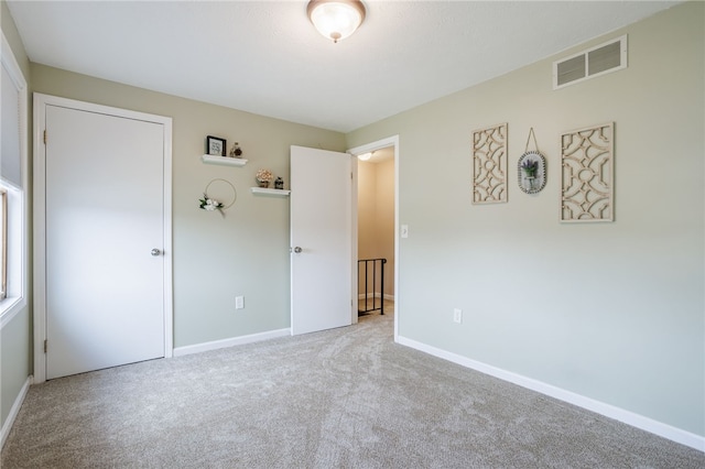 unfurnished bedroom featuring visible vents, carpet flooring, and baseboards