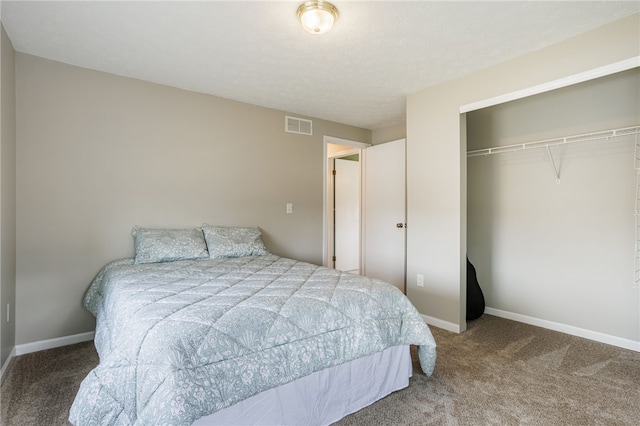 carpeted bedroom featuring a closet, visible vents, a textured ceiling, and baseboards