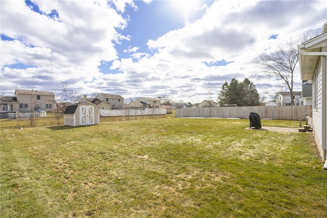 view of yard with a storage unit, an outbuilding, and a fenced backyard