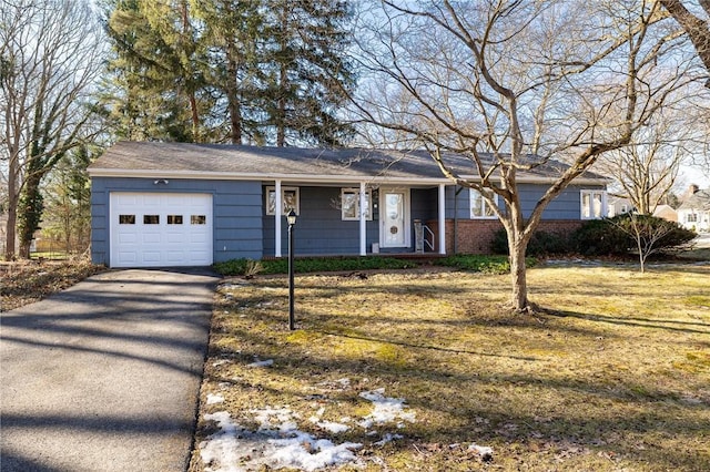 ranch-style home featuring a front yard, an attached garage, brick siding, and driveway