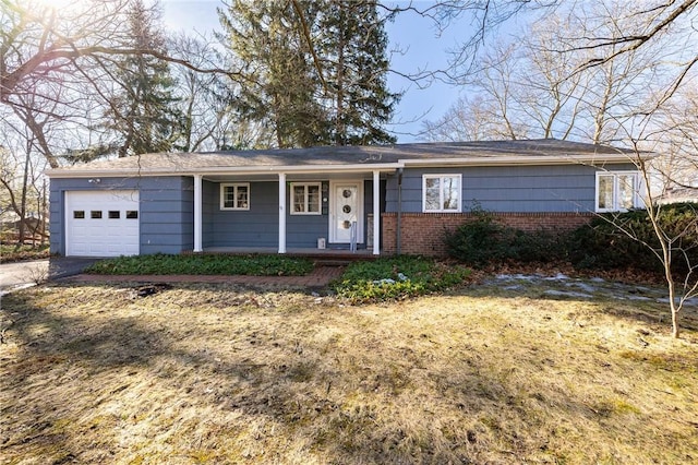 ranch-style home with brick siding, covered porch, and an attached garage