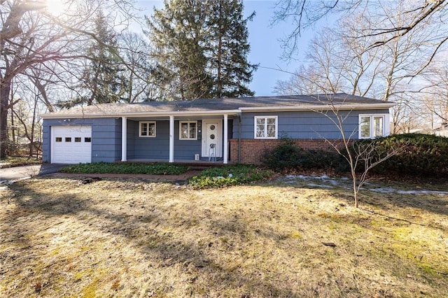 ranch-style house featuring a garage, brick siding, a porch, and driveway