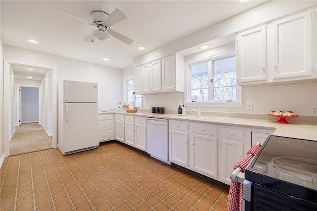 kitchen featuring white appliances, white cabinets, recessed lighting, and light countertops