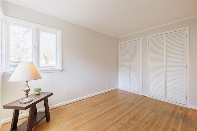 interior space featuring light wood-style floors, baseboards, and ornamental molding