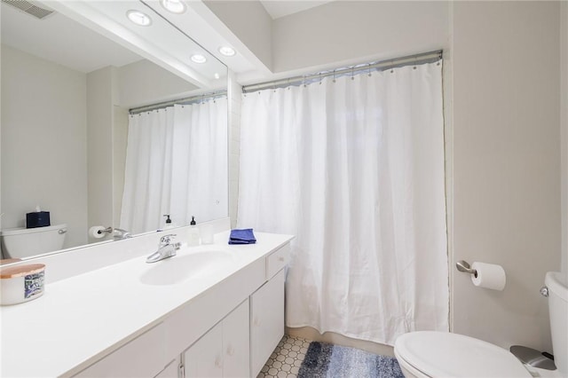 bathroom with visible vents, curtained shower, toilet, and vanity