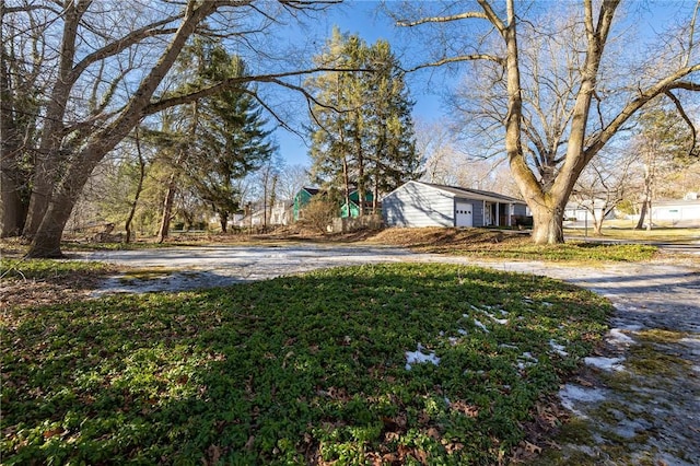 view of yard with a garage and driveway