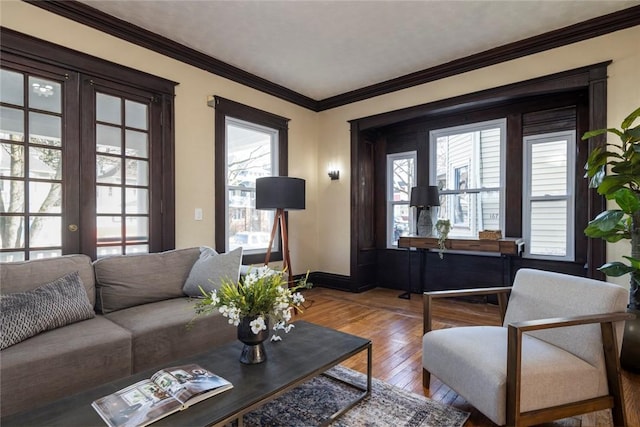 living area with french doors, wood-type flooring, baseboards, and ornamental molding