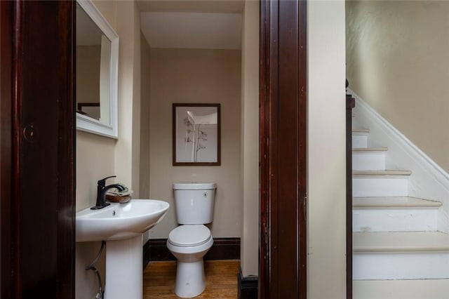 bathroom featuring a sink, baseboards, toilet, and wood finished floors