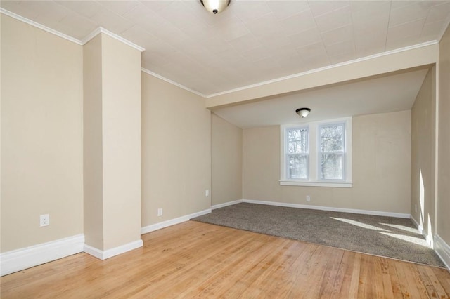 unfurnished room with crown molding, wood finished floors, and baseboards