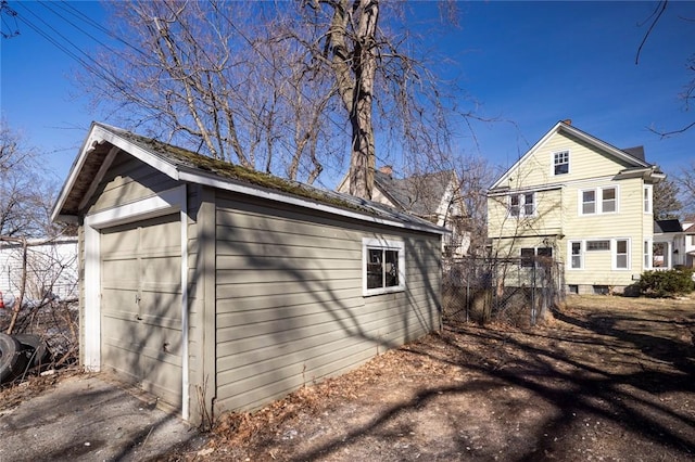 exterior space with driveway, a detached garage, and an outdoor structure