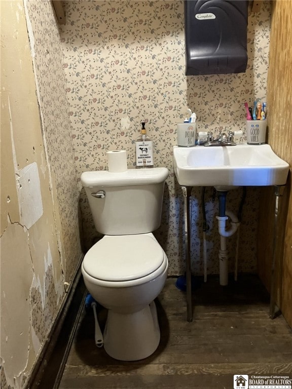 half bath with toilet and wood finished floors