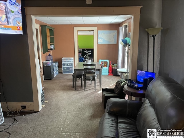 living room featuring carpet flooring and a paneled ceiling