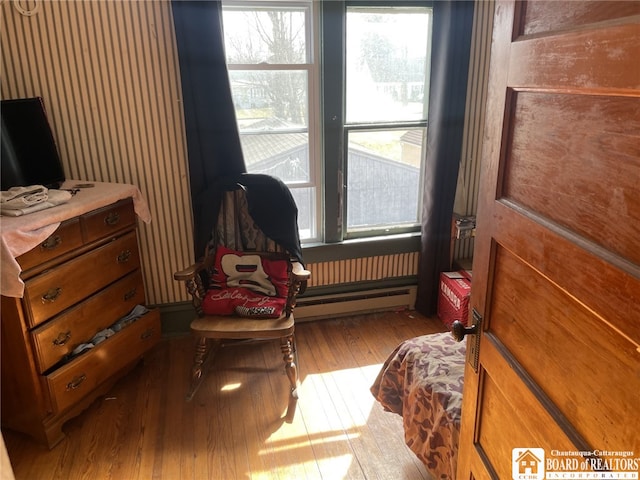 sitting room featuring a baseboard heating unit and hardwood / wood-style floors