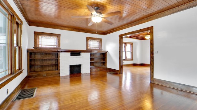 unfurnished living room featuring visible vents, a brick fireplace, wooden ceiling, and crown molding