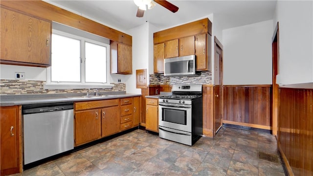 kitchen with a sink, decorative backsplash, brown cabinetry, and stainless steel appliances