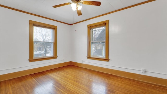 unfurnished room featuring a ceiling fan, crown molding, baseboards, and wood finished floors