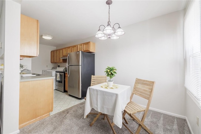 dining room with washer / dryer, light carpet, baseboards, and a chandelier