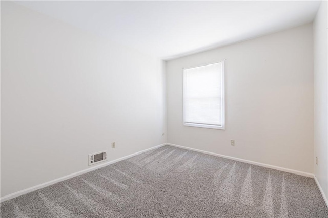 carpeted empty room featuring baseboards and visible vents