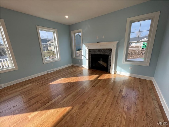 unfurnished living room with visible vents, baseboards, and wood finished floors