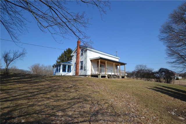 exterior space featuring a porch, a front yard, and a chimney