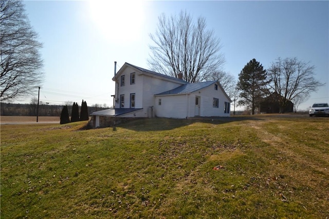 view of home's exterior featuring a lawn and a chimney