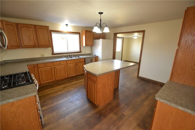 kitchen with a sink, a kitchen island, stainless steel dishwasher, freestanding refrigerator, and dark wood-style flooring