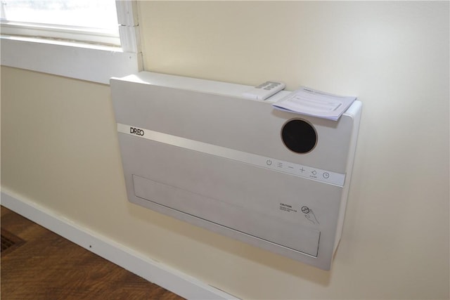 room details featuring baseboards, wood finished floors, and a wall mounted AC