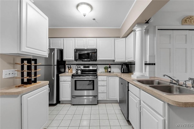 kitchen featuring a sink, white cabinetry, appliances with stainless steel finishes, and ornate columns