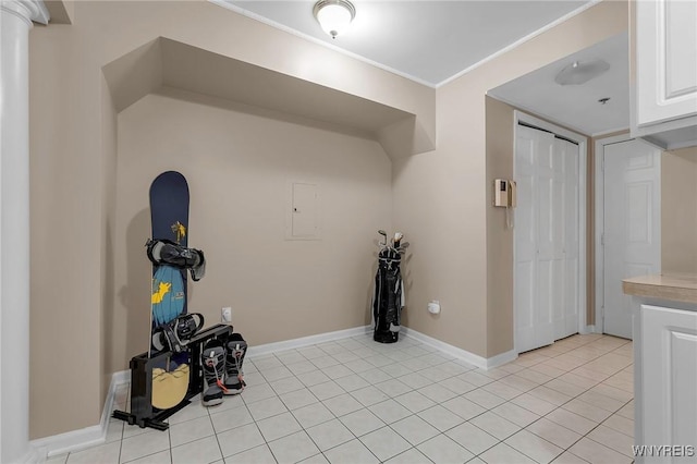 interior space with light tile patterned floors, baseboards, and ornamental molding