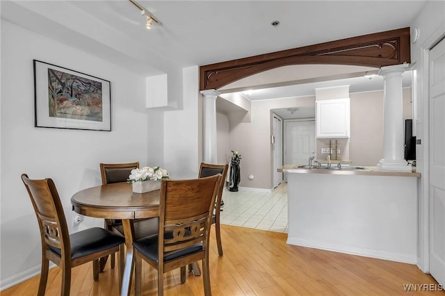 233 Richmond Ave Unit 15, Buffalo, NY 14222 - dining room with baseboards, rail lighting, light wood-type flooring, and decorative columns