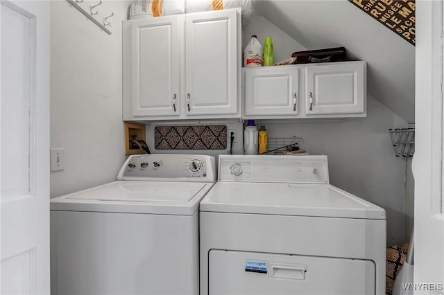 clothes washing area with washing machine and dryer and cabinet space