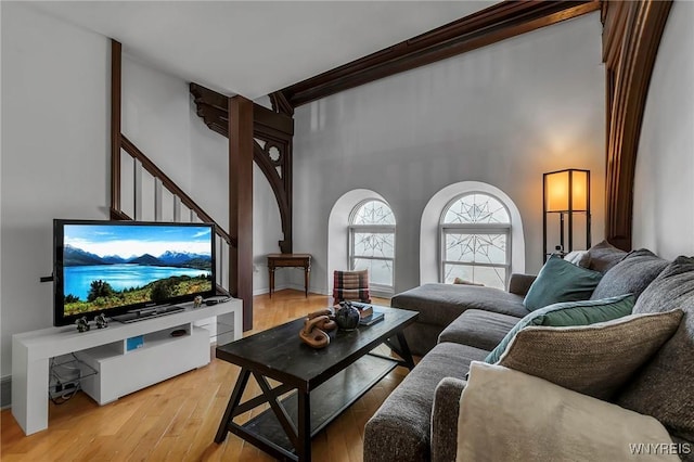 living room featuring light wood finished floors and a towering ceiling